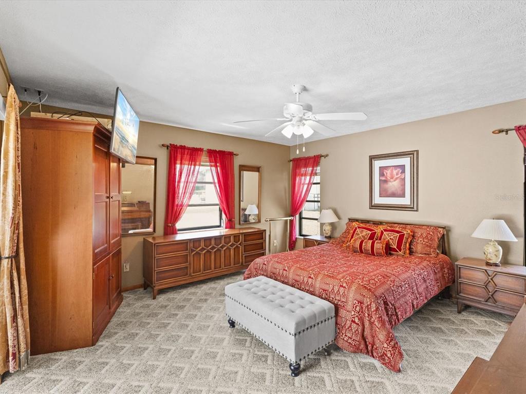 10700 Luscombe Court New Port Richey, FL 34654 - Photo 21 of 64 a bedroom with a bed and a dresser next to a window