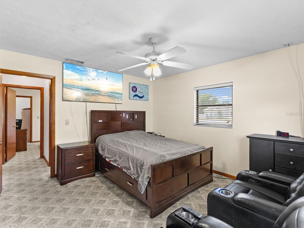 10700 Luscombe Court New Port Richey, FL 34654 - Photo 27 of 64 a bedroom with a bed and a chandelier