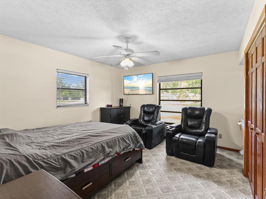 10700 Luscombe Court New Port Richey, FL 34654 - Photo 28 of 64 a bedroom with a bed a couch and a window