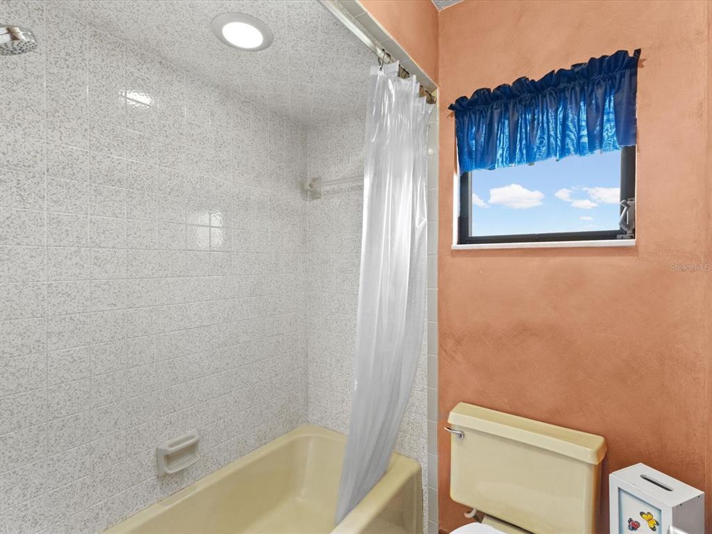 10700 Luscombe Court New Port Richey, FL 34654 - Photo 30 of 64 a bathroom with a toilet and a shower curtain