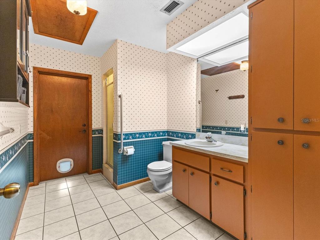 10700 Luscombe Court New Port Richey, FL 34654 - Photo 32 of 64 a bathroom with a granite countertop sink toilet and mirror