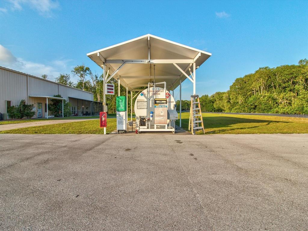 10700 Luscombe Court New Port Richey, FL 34654 - Photo 52 of 64 a view of a swimming pool with a lawn chairs under an umbrella