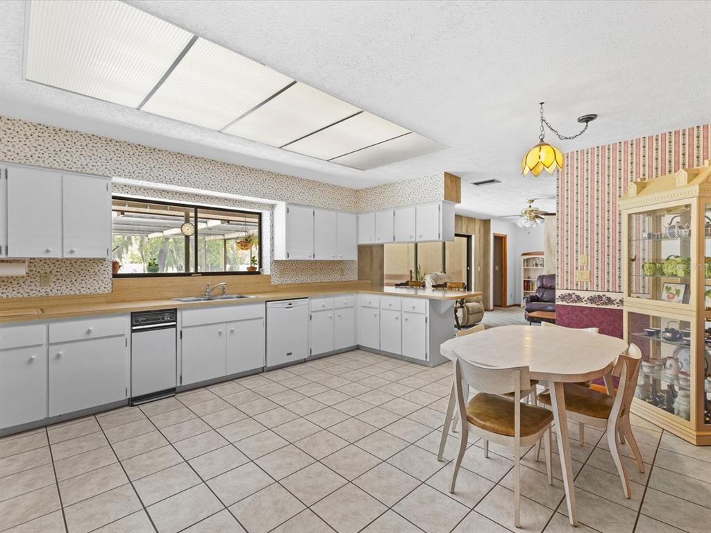 10700 Luscombe Court New Port Richey, FL 34654 - Photo 6 of 64 a kitchen with cabinets and chairs