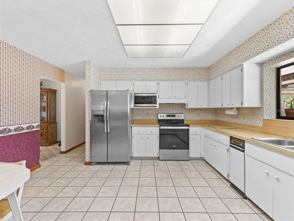 10700 Luscombe Court New Port Richey, FL 34654 - Photo 7 of 64 a kitchen with stainless steel appliances granite countertop a refrigerator and a sink