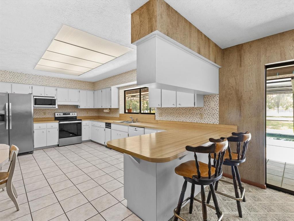 10700 Luscombe Court New Port Richey, FL 34654 - Photo 10 of 64 a kitchen with cabinets and chairs