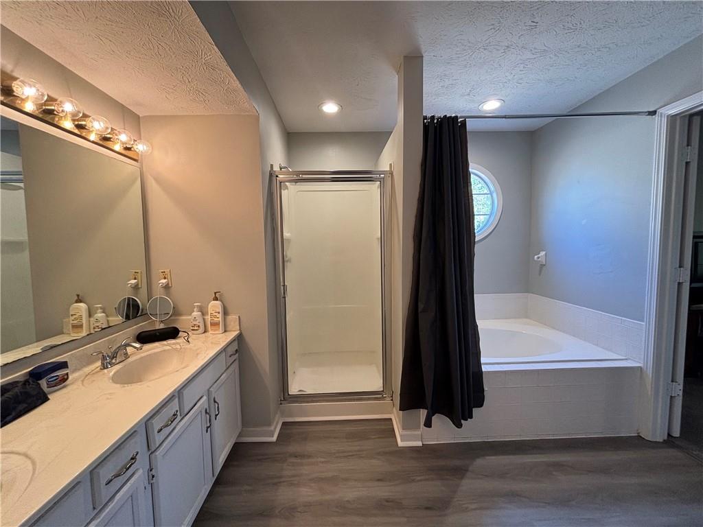 4949 Penscot Way Stone Mountain, GA 30088 - Photo 32 of 40 a bathroom with a double vanity sink a mirror and a bathtub