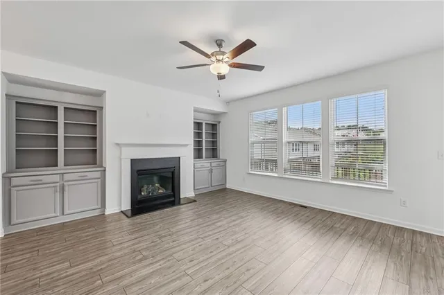 a view of an empty room with a fireplace and a window