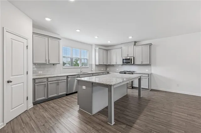 a kitchen with a sink cabinets and wooden floor
