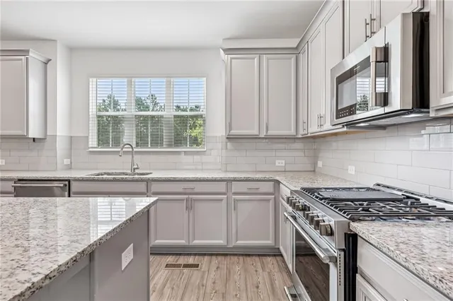 a kitchen with stainless steel appliances granite countertop a stove and a sink