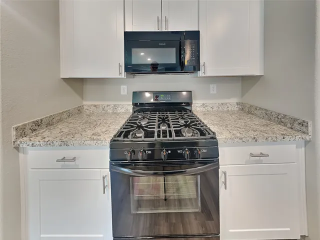 a stove top oven sitting inside of a kitchen