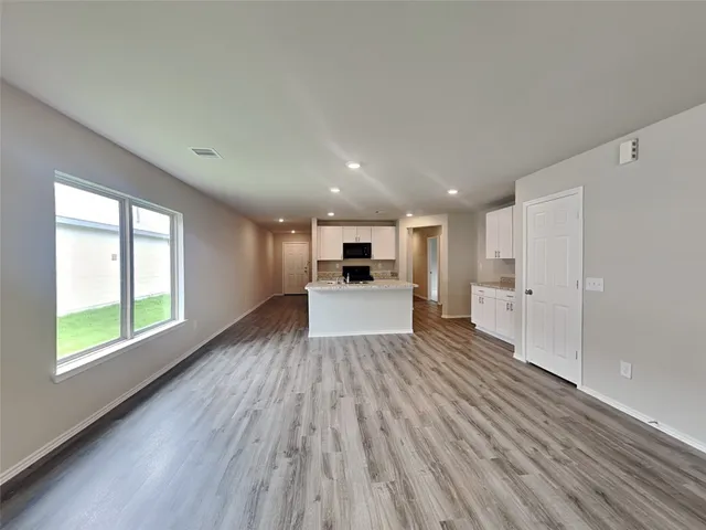 a view of a kitchen with wooden floor and windows