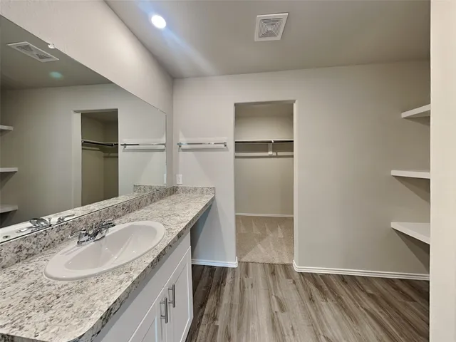 a bathroom with a granite countertop sink and a mirror