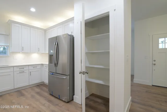 a kitchen with white cabinets and a window