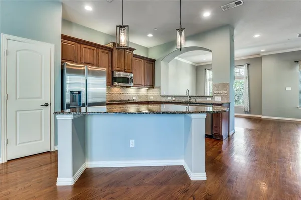 a kitchen with stainless steel appliances granite countertop a stove a sink and a microwave
