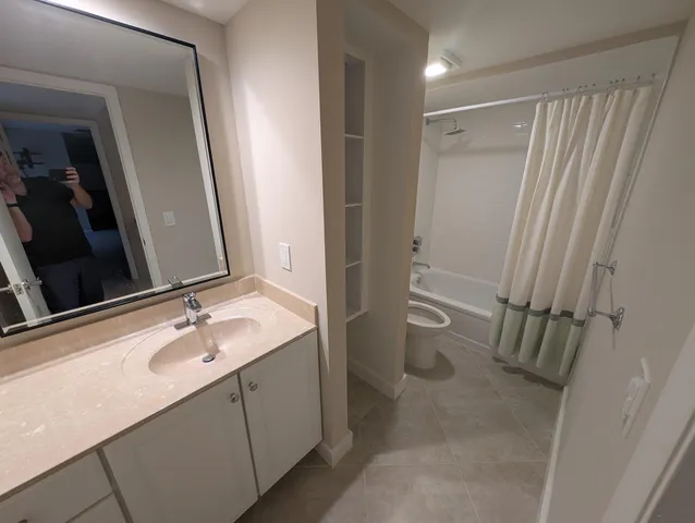 a bathroom with a sink a toilet and a mirror