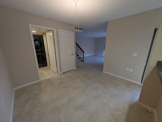 an empty room with staircase and a ceiling fan