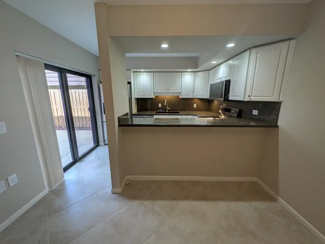 a kitchen with kitchen island granite countertop a sink and a stove top oven