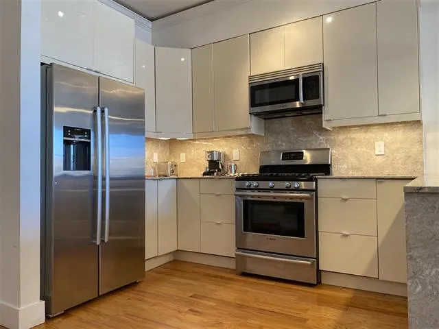 a kitchen with stainless steel appliances granite countertop a refrigerator and a microwave