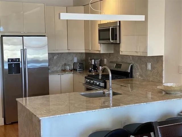 a kitchen with a sink a microwave and cabinets