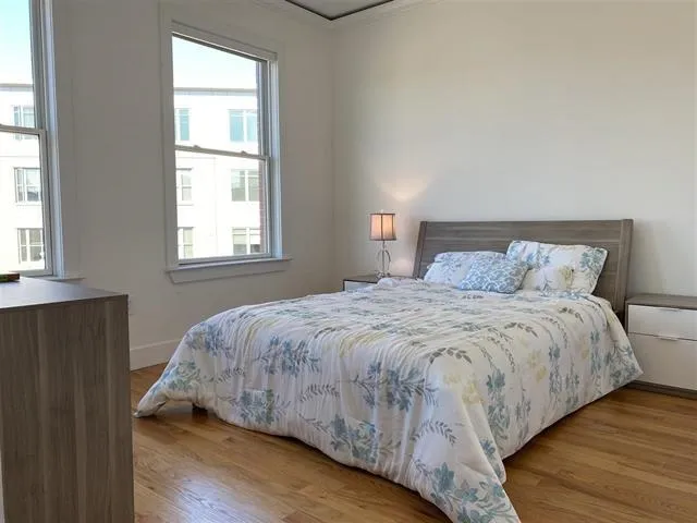 a bedroom with a bed and wooden floor