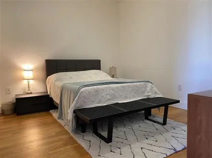 a bedroom with a bed and wooden floor