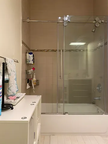 a bathroom with a sink vanity and shower