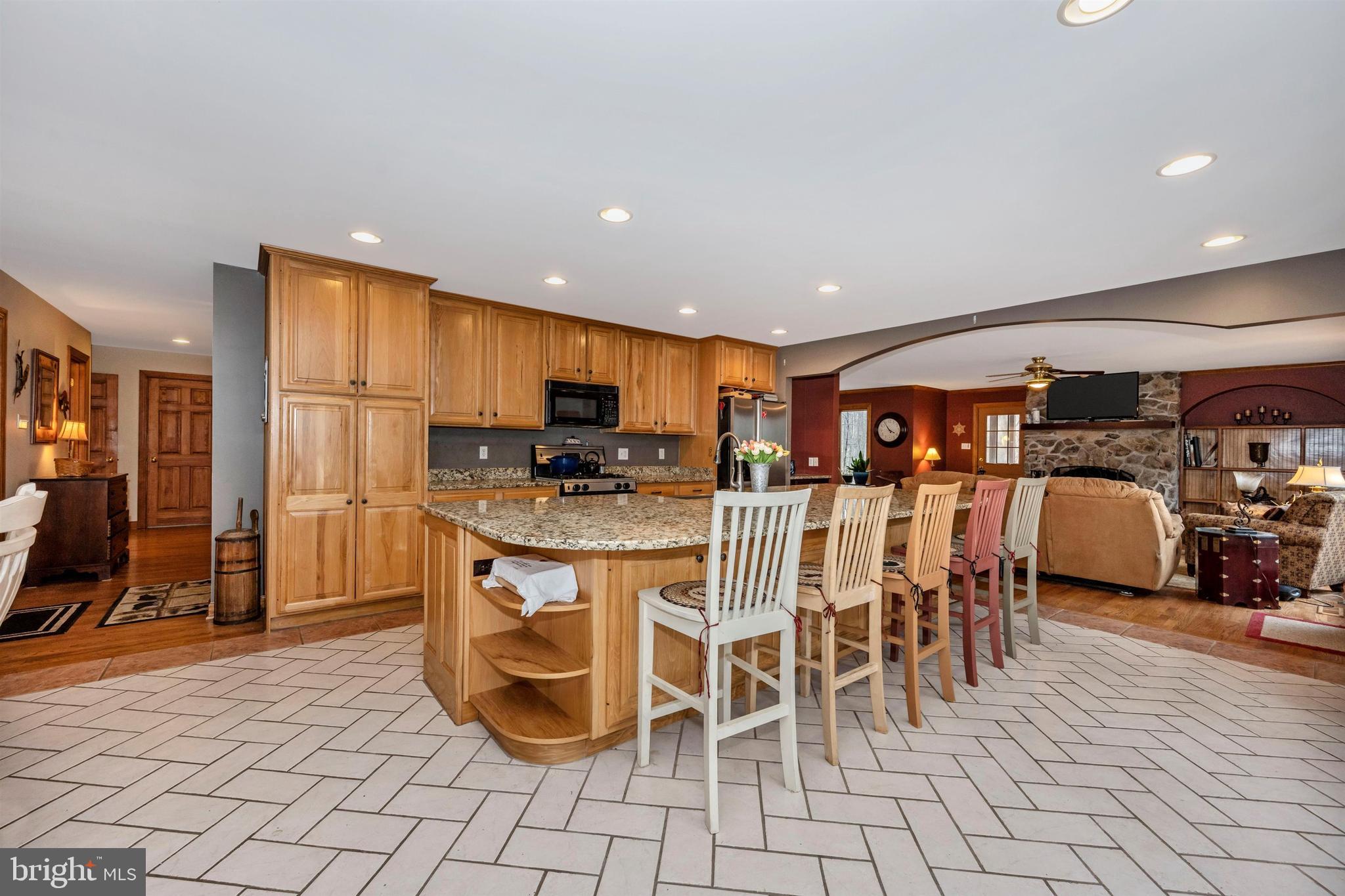5130 Shookstown Road Frederick, MD 21702 - Photo 17 of 87 a kitchen with stainless steel appliances kitchen island granite countertop a refrigerator cabinets and chairs