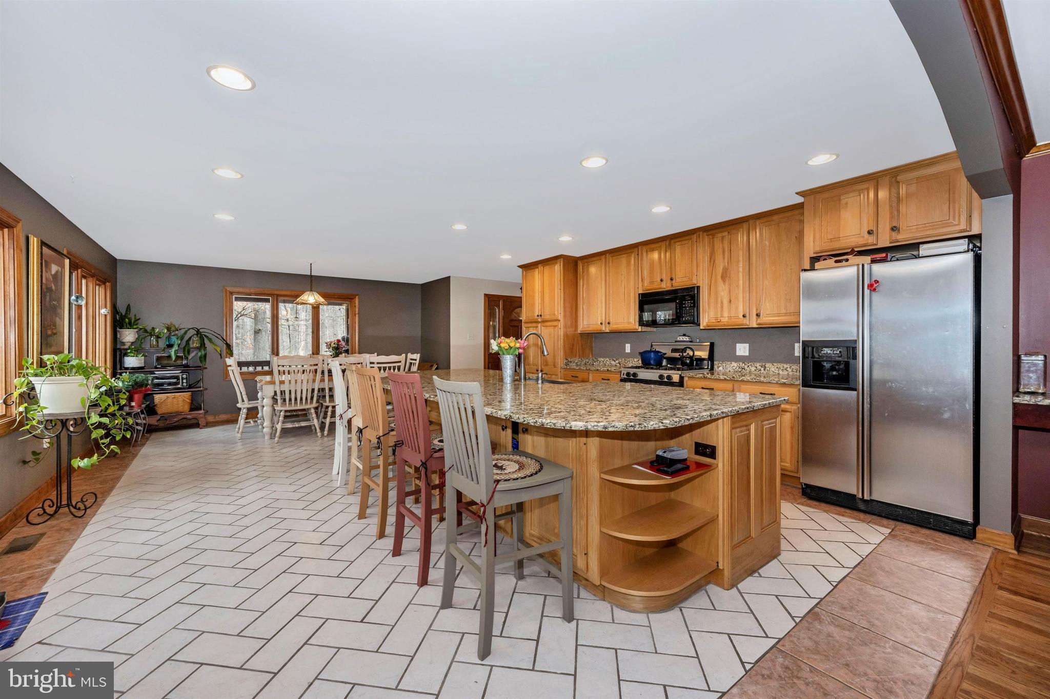 5130 Shookstown Road Frederick, MD 21702 - Photo 18 of 87 a kitchen with stainless steel appliances granite countertop a refrigerator a stove a sink a dining table and chairs with wooden floor