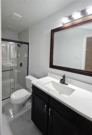 a bathroom with a sink a toilet and shower