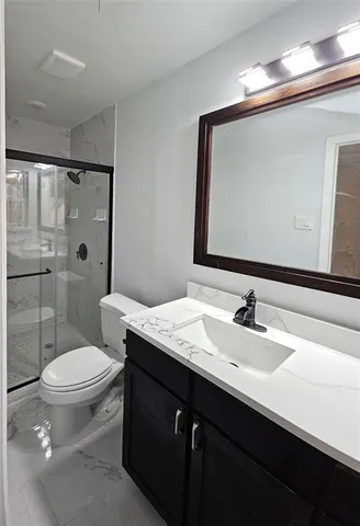 a bathroom with a sink a toilet and shower