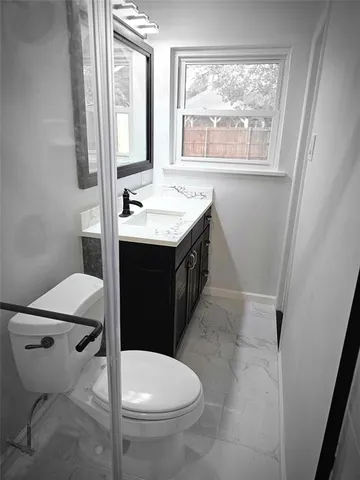 a bathroom with a sink toilet and window