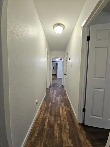 a view of a hallway with wooden floor and closet