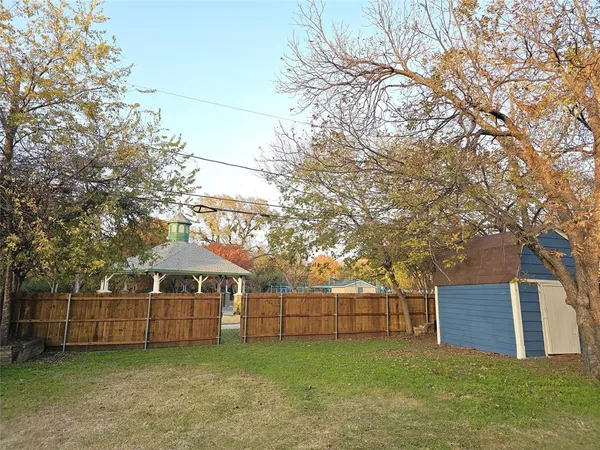 a view of a house with a yard and large tree