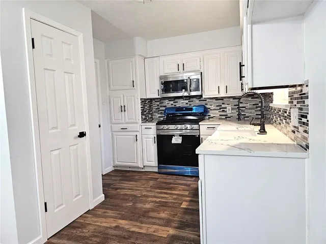 a kitchen with appliances a sink and cabinets