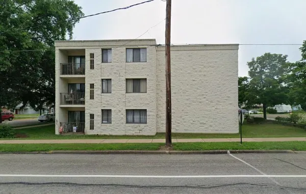 a view of a brick house next to a yard