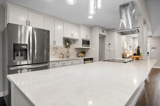 a kitchen with stainless steel appliances a refrigerator sink and microwave