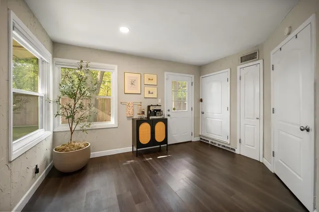 a view of an empty room with window wooden floor and front door