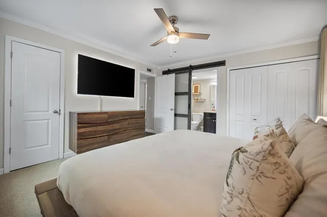 a bedroom with a large bed and a flat screen tv
