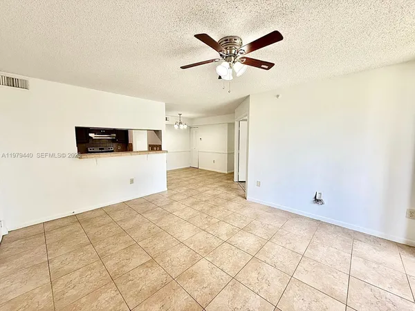 a view of a livingroom with an empty space and a ceiling fan