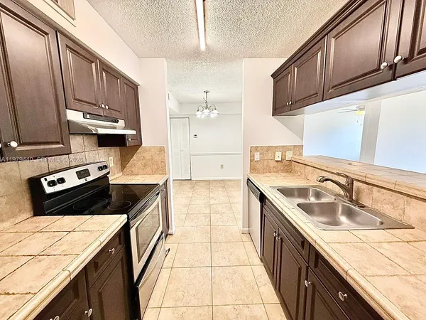 a kitchen with stainless steel appliances granite countertop a sink stove and cabinets
