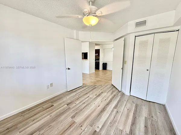 an empty room with windows and wooden floor