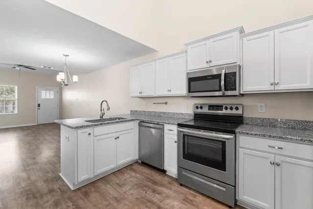 a kitchen with stainless steel appliances granite countertop a sink a stove a microwave and cabinets