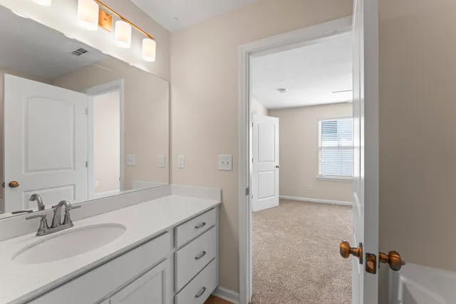 a bathroom with a granite countertop sink mirror and vanity