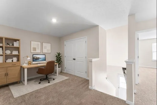 a view of a workspace with furniture and a window