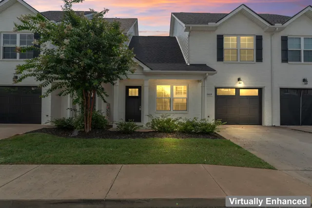 a front view of a house with a yard and a garage