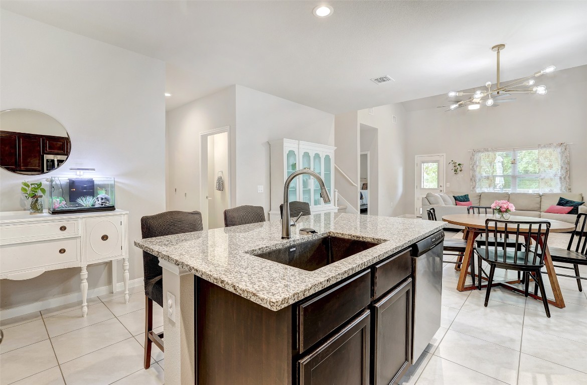 6709 Branrust Drive Austin, TX 78744 - Photo 8 of 35 a kitchen with granite countertop a table chairs sink and cabinets