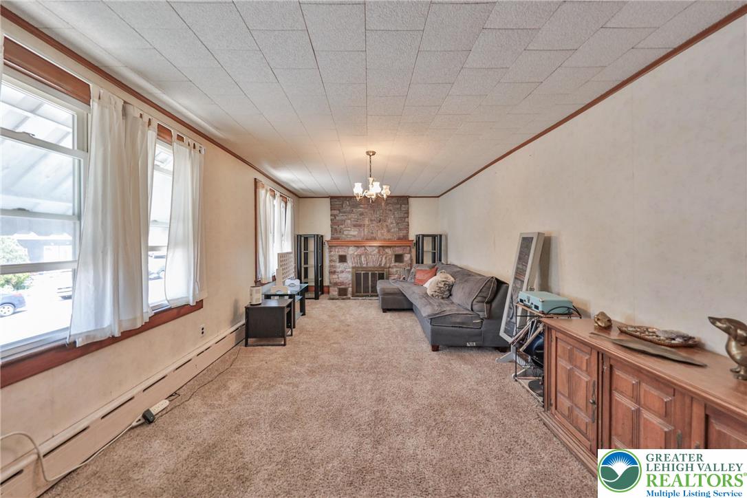 417 3rd Street Lehighton, PA 18235 - Photo 19 of 39 An inviting living room features a stone fireplace, overhead chandelier, and light-filled windows.