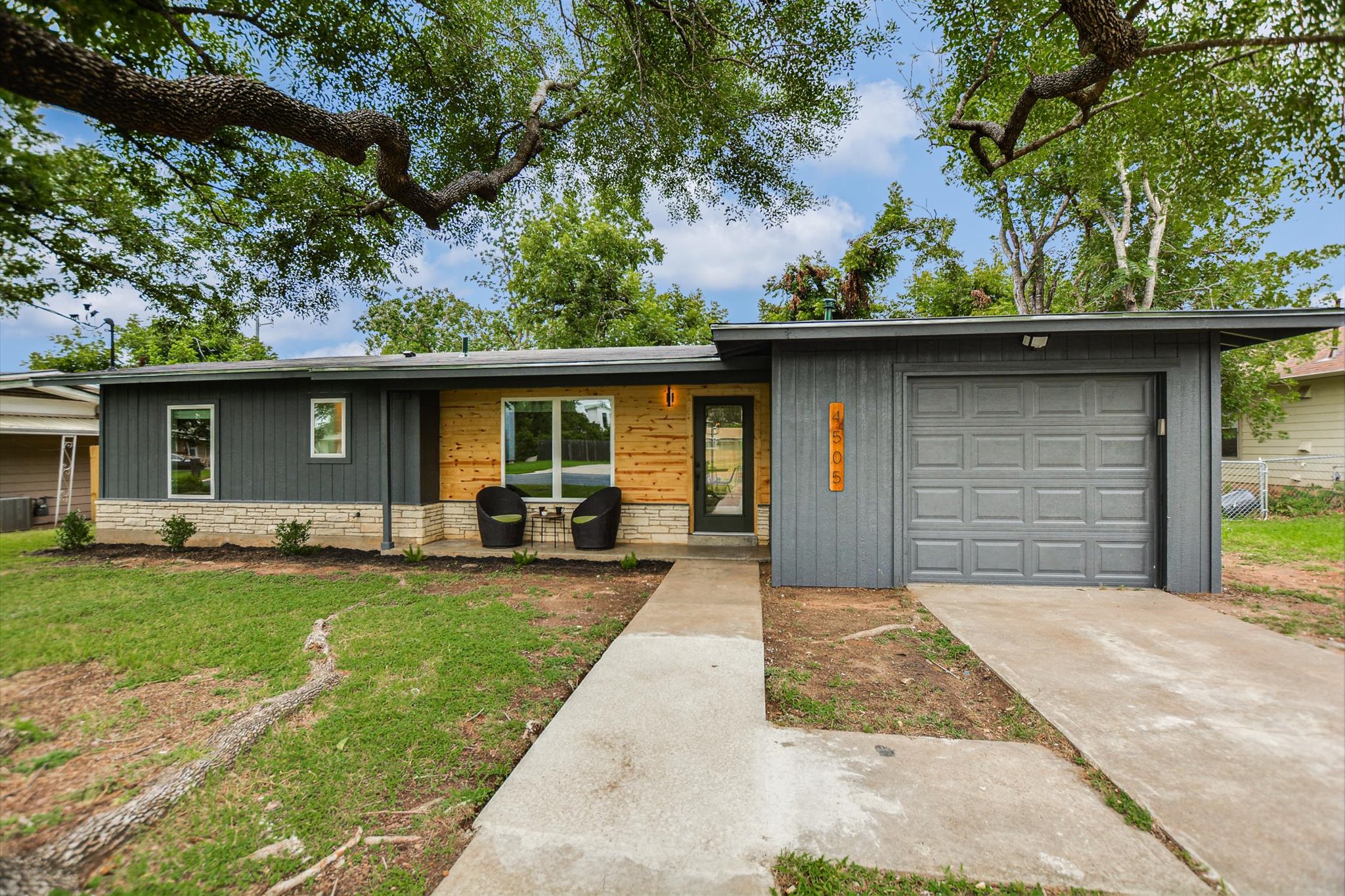A striking modern facade with contrasting wood and charcoal siding, offering inviting curb appeal.