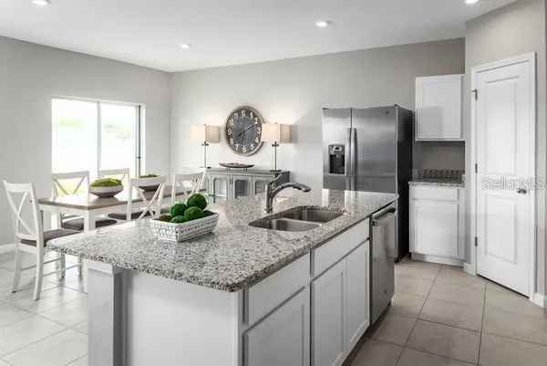 a kitchen with stainless steel appliances granite countertop a sink and a refrigerator