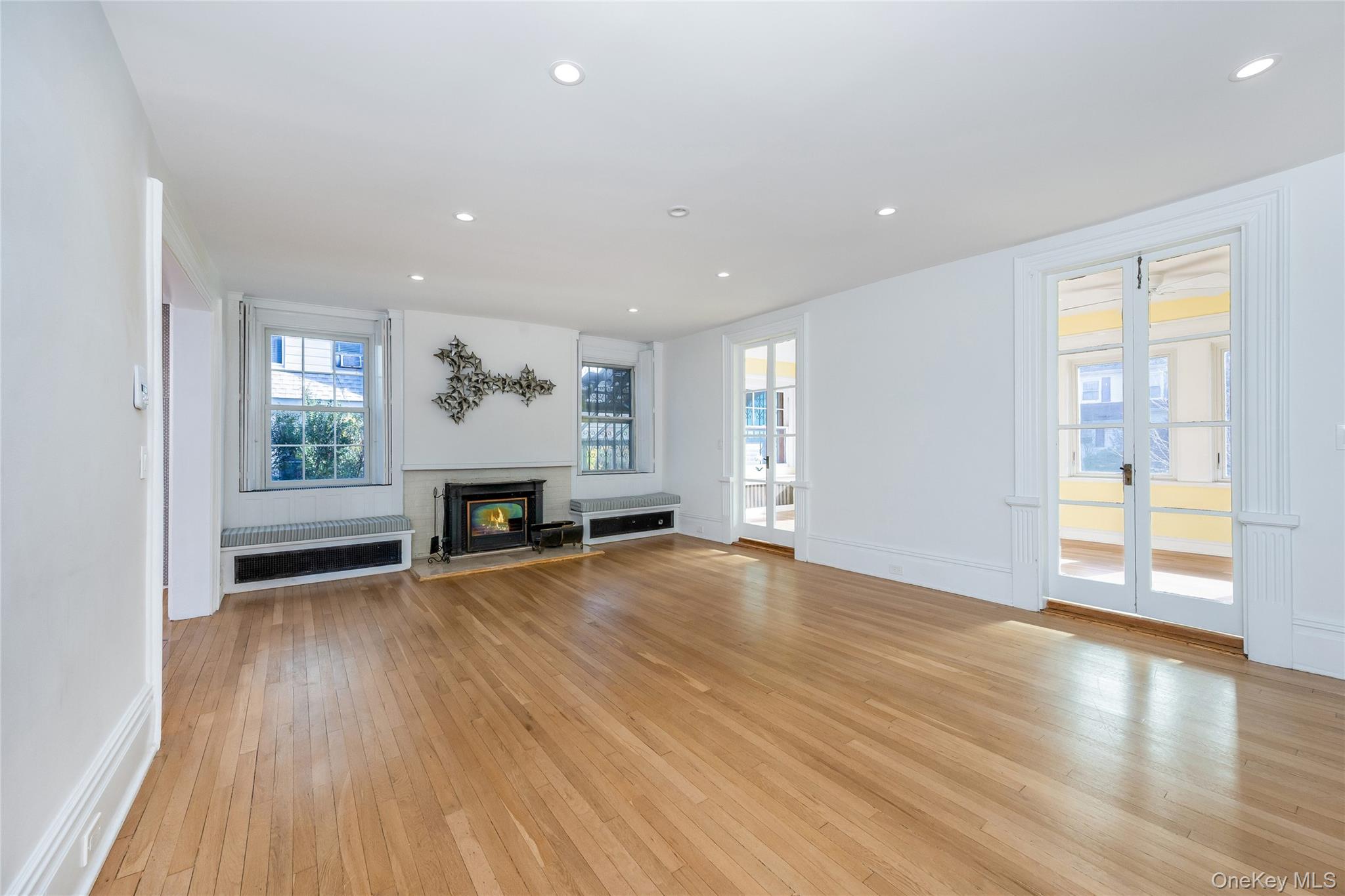 41 French Ridge New Rochelle, NY 10801 - Photo 5 of 50 an empty room with wooden floor fireplace and windows